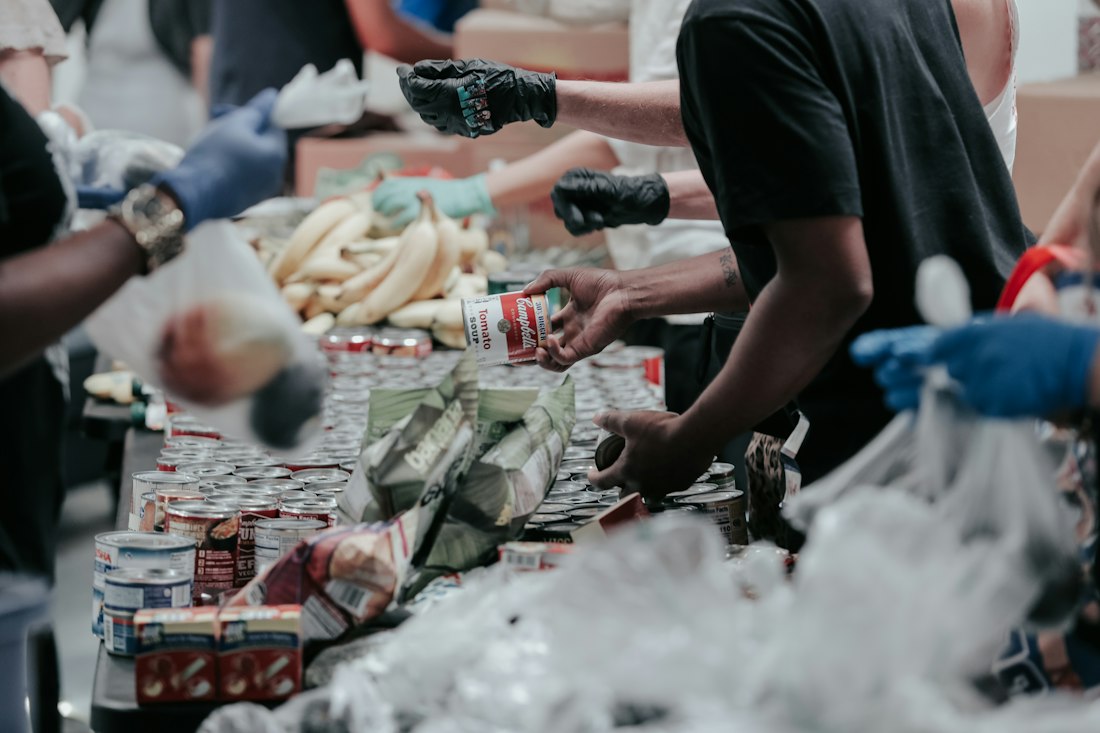 Hands passing canned goods along a sorting line